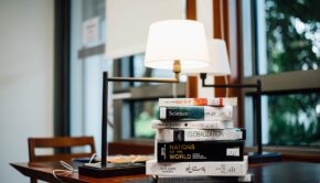 Стопка книг под лампой