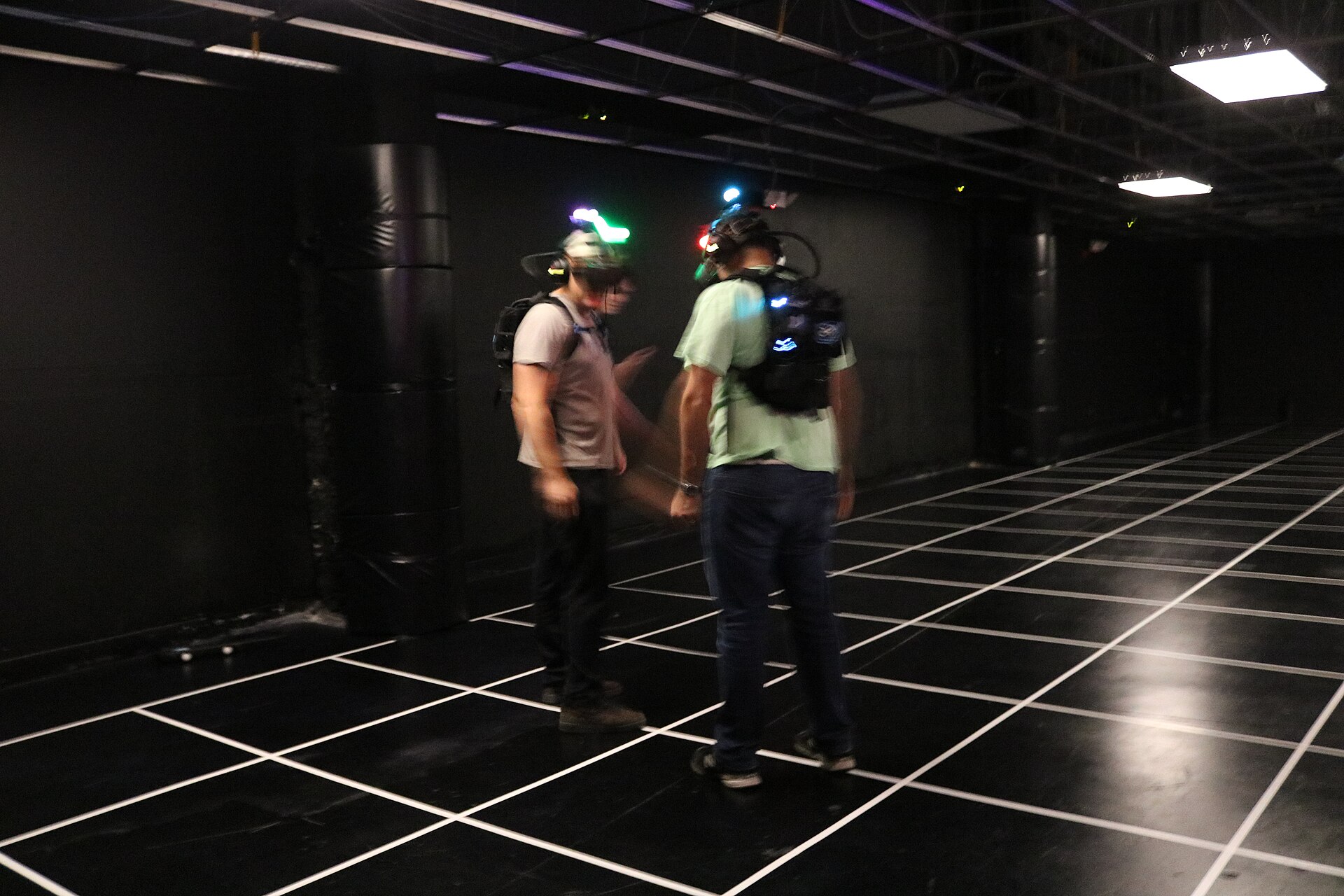 Игроки в VR-шлемах в арене виртуальной реальности